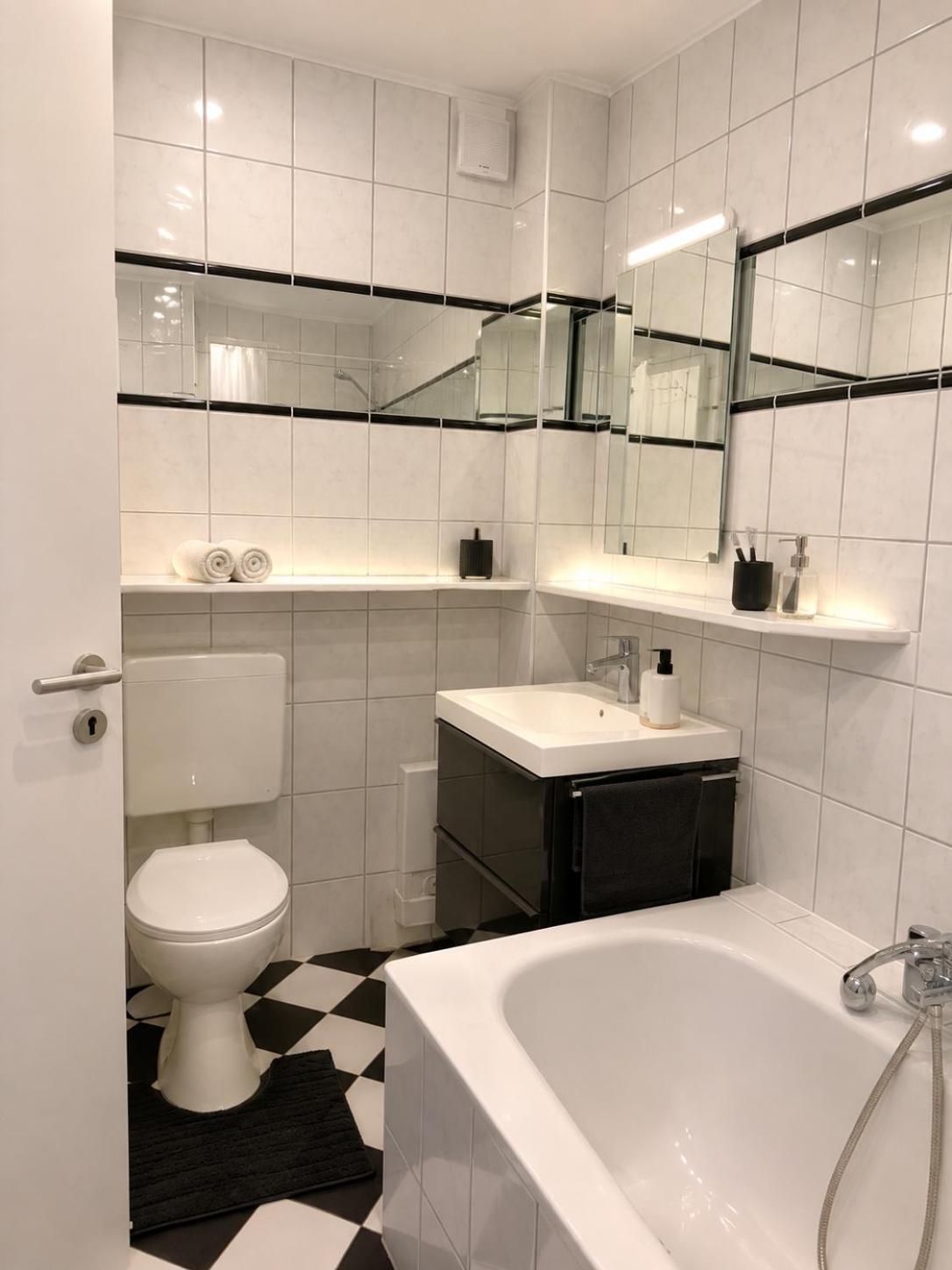 Badezimmer mit Waschbecken und Badewanne – Altstadt Living Deluxe