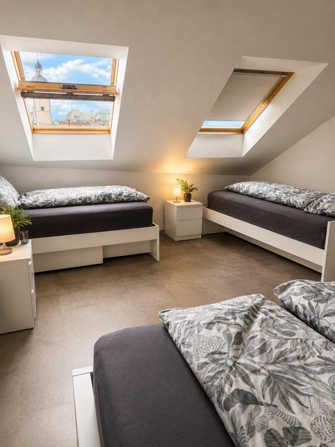 Schlafbereich mit Einzelbetten unter den Dachfenstern – Altstadt Living